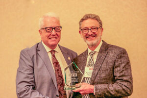 Frank O'Connell (left) accepts the 2025 Paull Mines Award presented by Ray Langenberg (right).